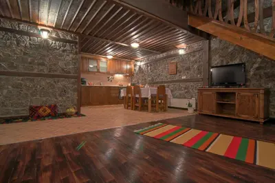 a living room with a tv and a wooden floor at Holiday Village Kochorite in Pamporovo