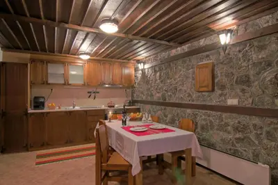 a kitchen with a table and chairs in a room at Holiday Village Kochorite in Pamporovo