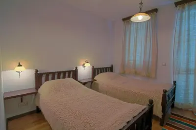 a bedroom with two beds and a window at Holiday Village Kochorite in Pamporovo