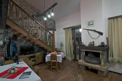 a living room with a staircase and a fireplace at Holiday Village Kochorite in Pamporovo