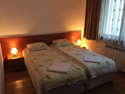 a bedroom with a large bed with two towels on it at Guest Rooms Vachin in Bansko