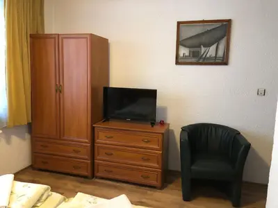 a bedroom with a television on a dresser and a chair at Guest Rooms Vachin in Bansko