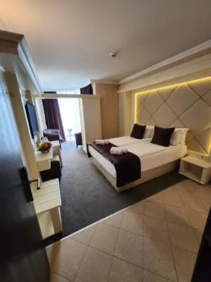 a hotel room with a bed and a living room at Park Hotel Plovdiv in Plovdiv