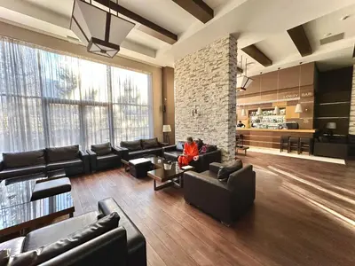 a person sitting on a couch in a living room at Terra Hotel in Bansko