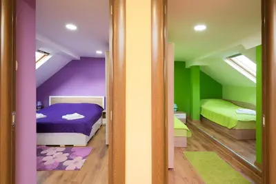 a room with two beds with purple and green at Serdika Round Tower Apartments in Sofia