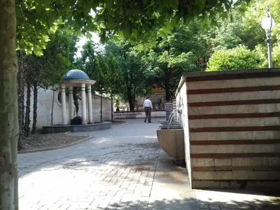 a man walking down a path in a park at Serdika Round Tower Apartments in Sofia