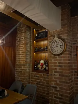 a clock on a brick wall in a restaurant at Family Hotel Lazur in Bansko