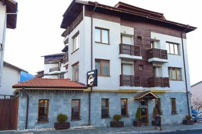 a tall white building with windows and balconies on it at Family Hotel Lazur in Bansko