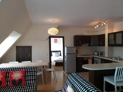 a kitchen and a living room with a table and chairs at Chamkoria Chalets in Borovets