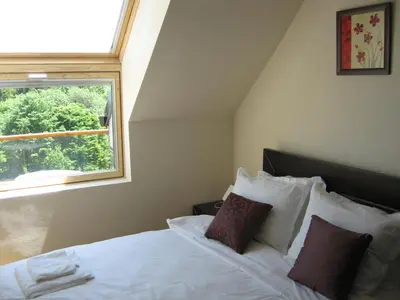 a bedroom with a white bed with a window at Chamkoria Chalets in Borovets