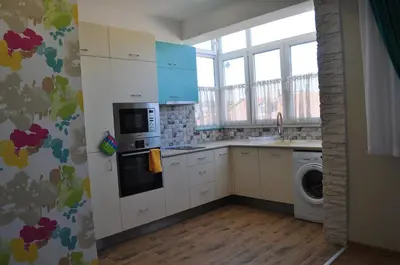 a kitchen with white cabinets and a washer and dryer at Sofia Central Pretty Apartment in Sofia