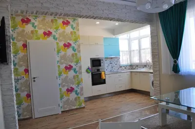 a kitchen with white cabinets and flowers on the wall at Sofia Central Pretty Apartment in Sofia