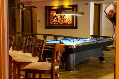 a pool table in a room with chairs at Complex Kamelia in Pamporovo