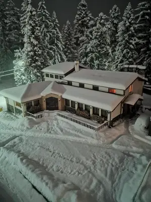 a building covered in snow with trees in the background at Saint George Borovets Hotel in Borovets