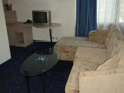 a living room with a couch and a table with a tv at Saint George Borovets Hotel in Borovets