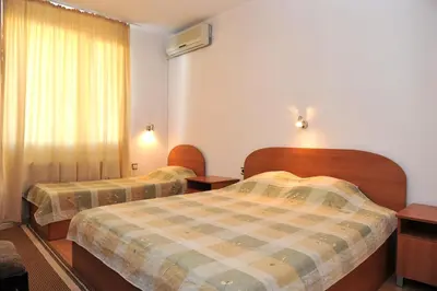 a hotel room with two beds and a window at Family Hotel Blazhi in Sandanski