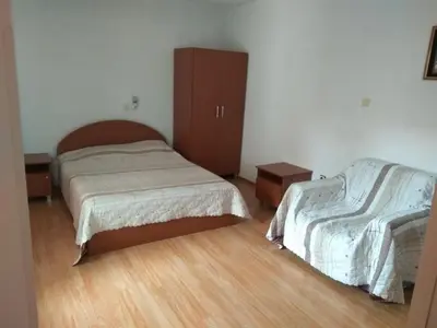a bedroom with two beds and a wooden floor at Family Hotel Blazhi in Sandanski