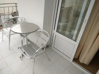 a balcony with a table and chairs and a window at Family Hotel Blazhi in Sandanski