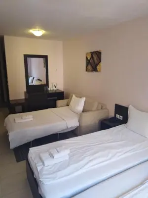 a hotel room with two beds and a couch at Maria-Antoaneta Residence in Bansko