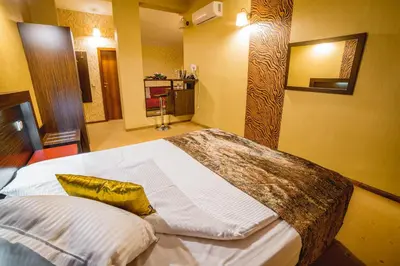 a bedroom with a large bed with a yellow pillow at Eleganza Family Hotel - Free Parking in Sofia
