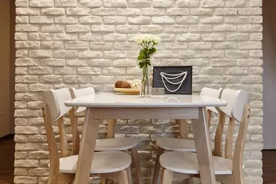 a table with white chairs and a vase with flowers at City Center Studio in Plovdiv