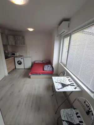 a small room with a red bed and a table at Sun Стамат Икономов 11 in Plovdiv
