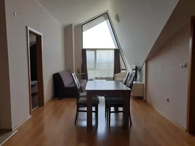 a dining room with a table and chairs and a window at Aspen Golf and Ski Resort in Bansko