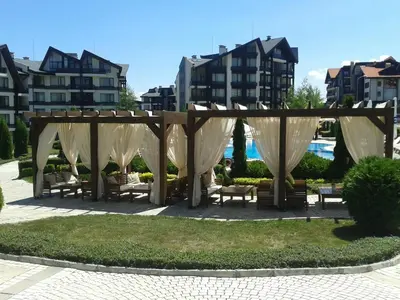a gazebo in a park with benches and buildings at Aspen Golf and Ski Resort in Bansko
