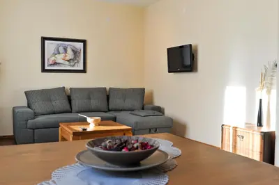 a living room with a bowl of fruit on a table at Guest House Dzhangal in Bansko