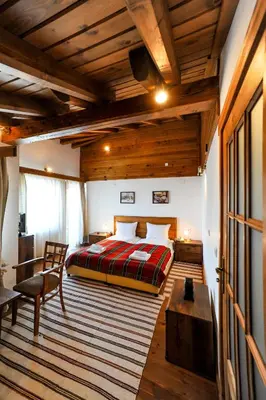 a bedroom with a bed and a wooden ceiling at Guest House Dzhangal in Bansko