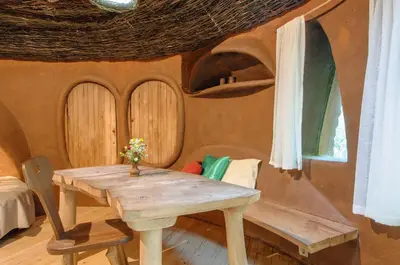 a room with a wooden table and a couch at Omaya Eco Village in Gaytaninovo