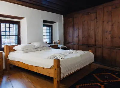 a bedroom with a large bed with wooden walls at Dedo Pene Inn in Bansko