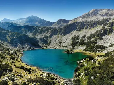 a mountain lake in the middle of a valley at Dedo Pene Inn in Bansko