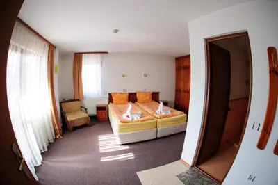 a small bedroom with a bed and a chair at Family Hotel Nadejda in Bansko