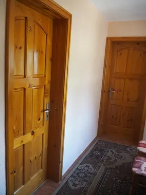 an empty room with a wooden door and a rug at Орбелус in Govedartsi