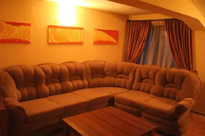 a large couch in a living room with a table at Guest House Valevicata in Bansko