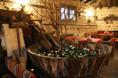 a large wooden tub filled with green plants in a room at Guest House Valevicata in Bansko