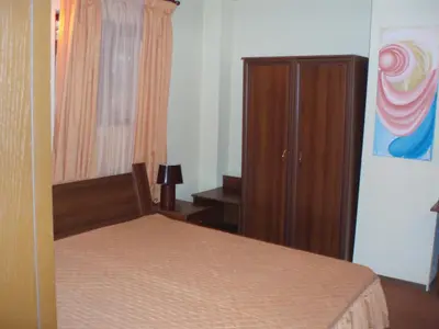 a bedroom with a bed and a wooden cabinet at Guest House Valevicata in Bansko