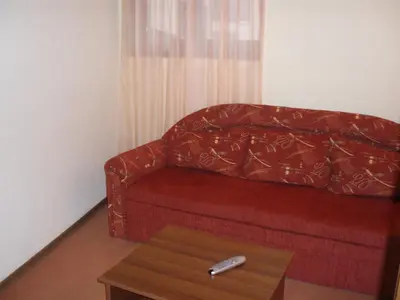 a red couch in a living room with a coffee table at Guest House Valevicata in Bansko