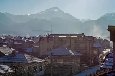 a city with buildings and a mountain in the background at Durchova Kashta Family Hotel in Bansko