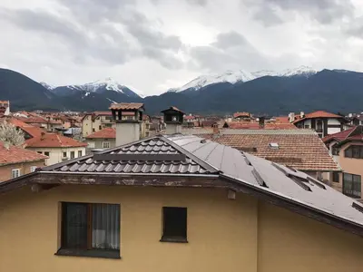 a roof of a building with mountains in the background at Durchova Kashta Family Hotel in Bansko