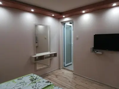 a bedroom with a flat screen tv and a mirror at Къща за гости Мира in Strelcha