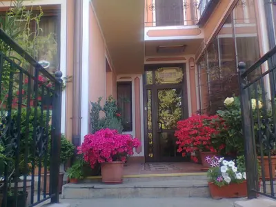 a front door of a house with pots of flowers at Hotel Alafrangite in Plovdiv