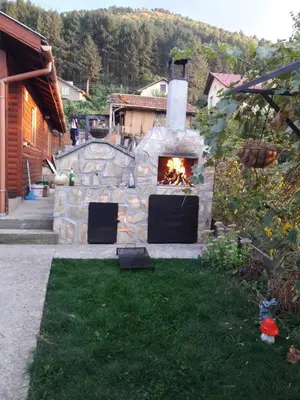 a stone oven with a fire in a yard at Holiday Home Veli in Sapareva Banya