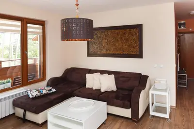 a living room with a brown couch and a table at Апартамент 