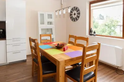 a kitchen and dining room with a wooden table and chairs at Апартамент 