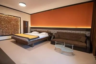 a bedroom with a bed and a couch at Family Hotel Bunara in Brestnik