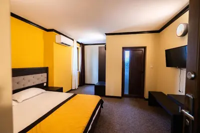 a hotel room with a bed and a flat screen tv at Family Hotel Bunara in Brestnik