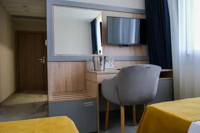 a room with a chair and a mirror at SPS Hotel in Plovdiv