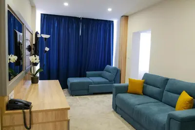 a living room with a blue couch and two chairs at SPS Hotel in Plovdiv